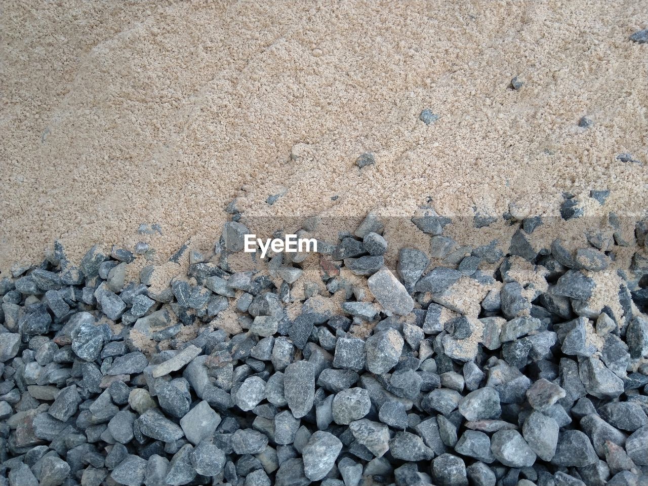 FULL FRAME SHOT OF PEBBLES ON SAND