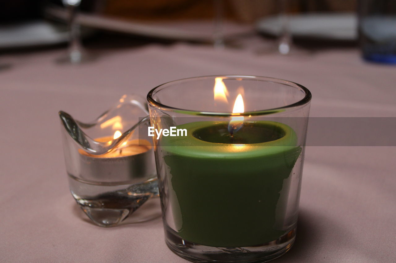 Close-up of illuminated tea light candles on table