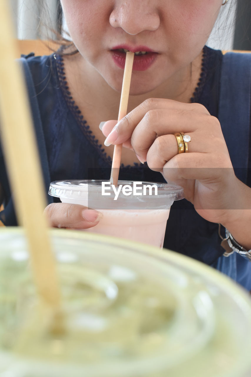 one person, food and drink, women, food, indoors, selective focus, adult, headshot, eating, child, female, portrait, person, holding, childhood, close-up, front view, table, baked, lifestyles, concentration, young adult, hand