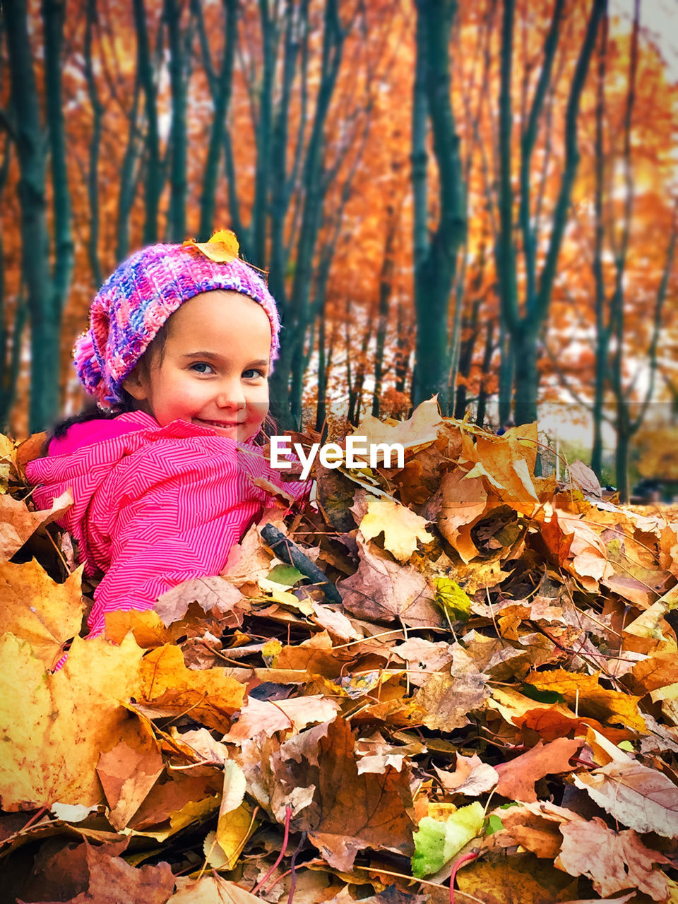 GIRL IN AUTUMN LEAVES ON TREE