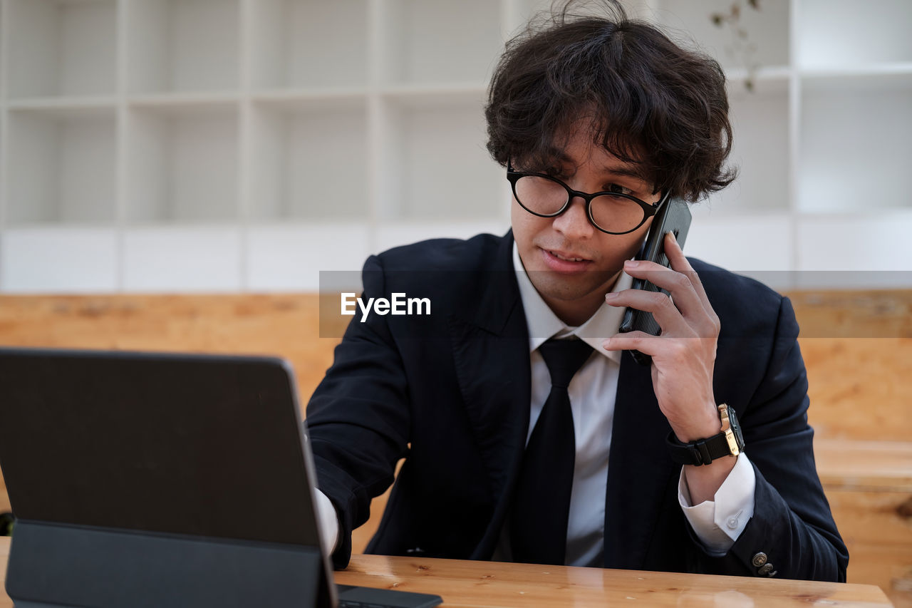 businesswoman using laptop while sitting on table in office