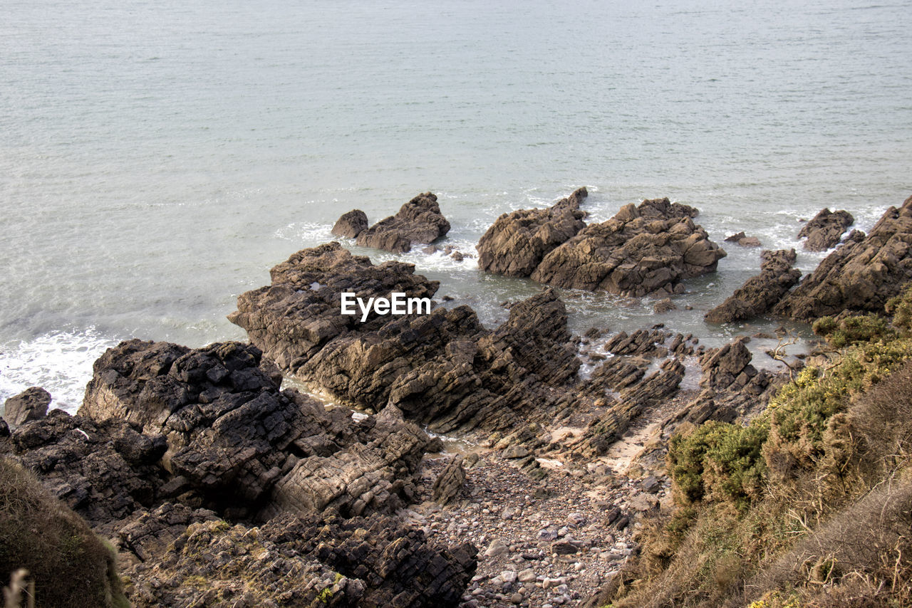 Rocks in sea against sky