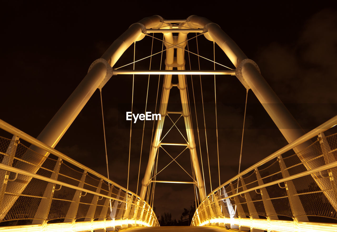 LOW ANGLE VIEW OF BRIDGE AT NIGHT