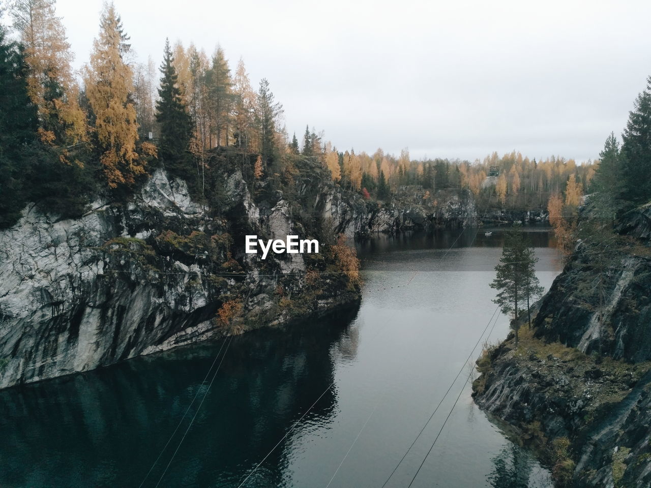 REFLECTION OF TREES IN LAKE AGAINST SKY