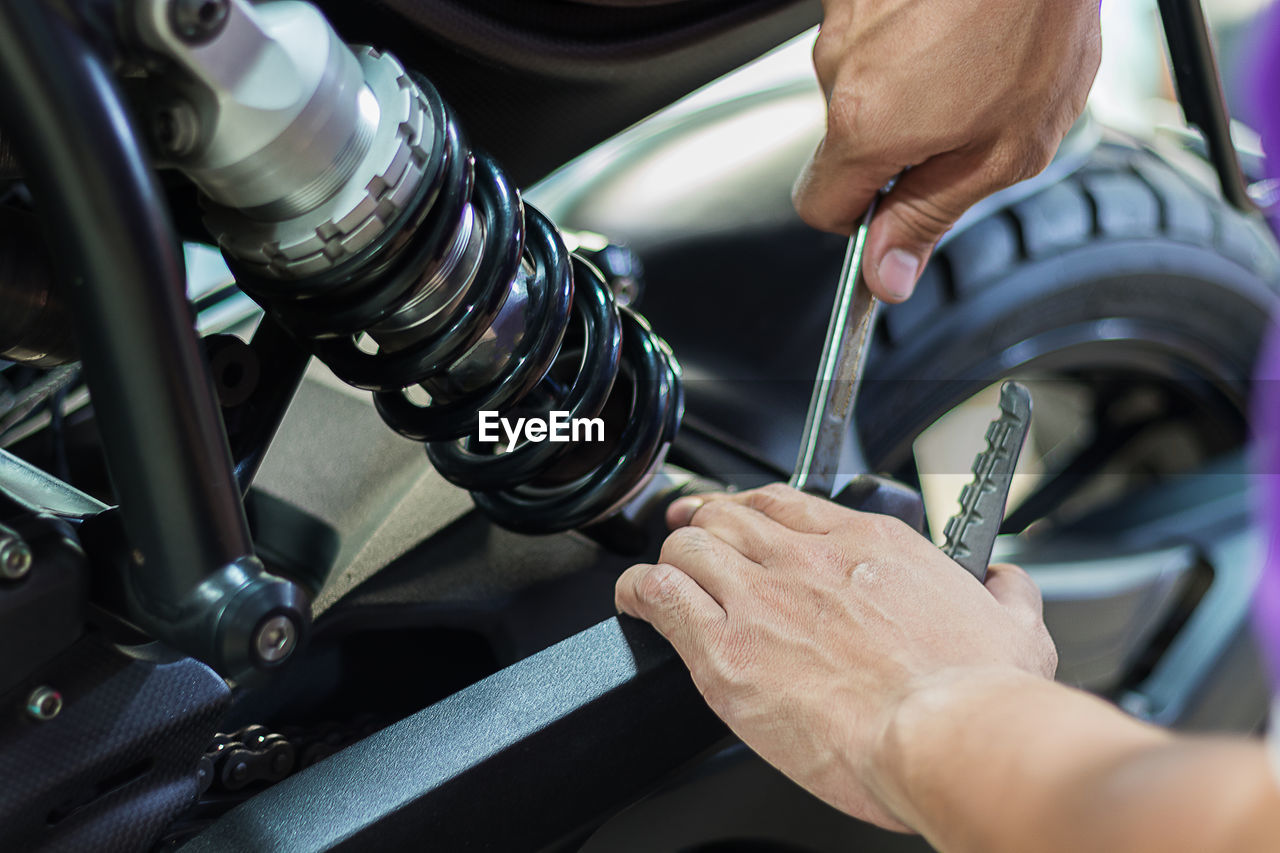 Cropped image of man repairing motorcycle at garage