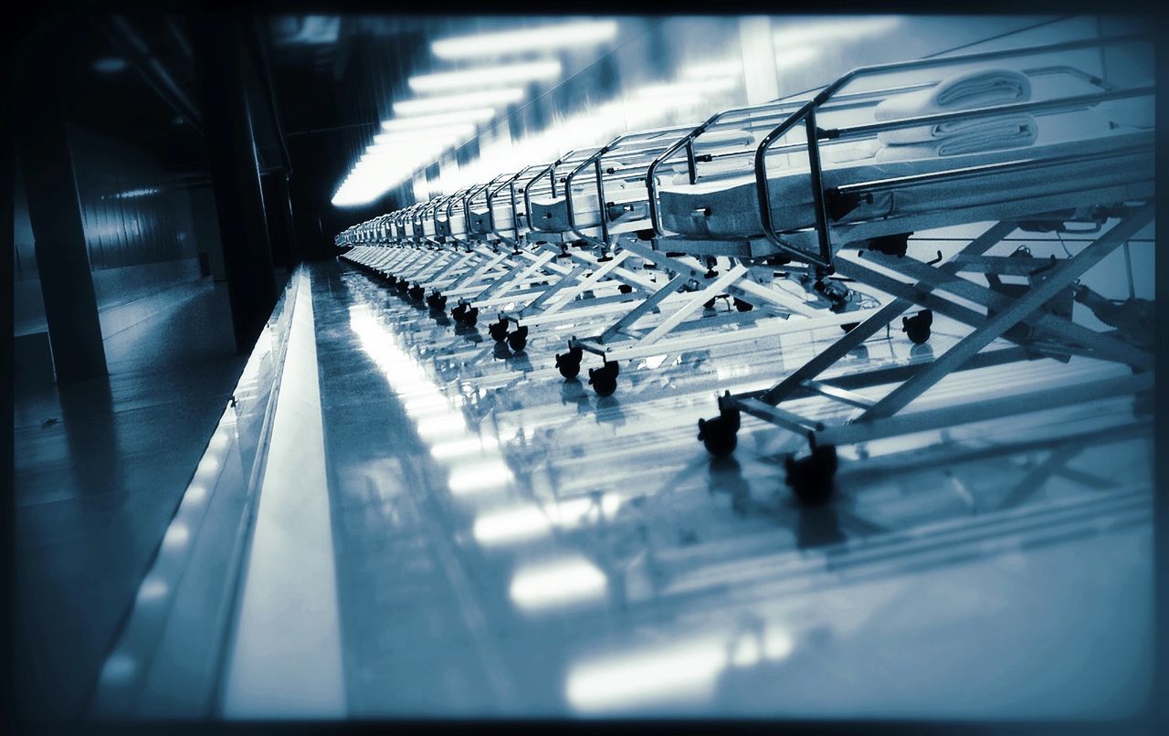 Row of empty beds with reflection on floor at cite des sciences et de lindustrie