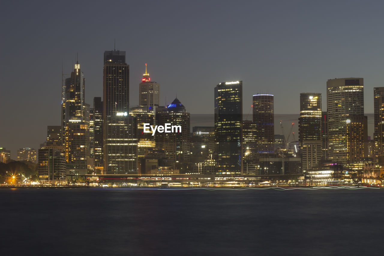 Illuminated buildings in city against sky at night