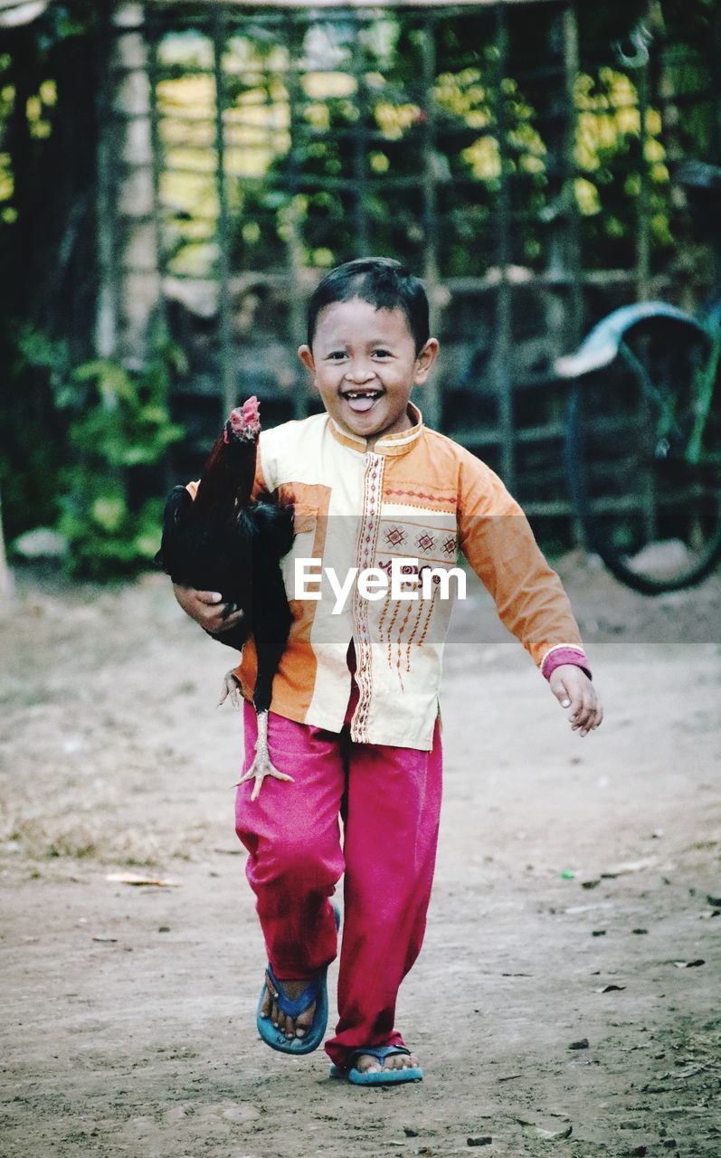 Portrait of smiling boy standing outdoors