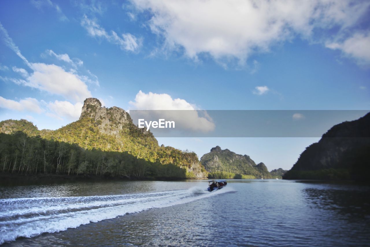 Scenic view of sea by mountains against sky