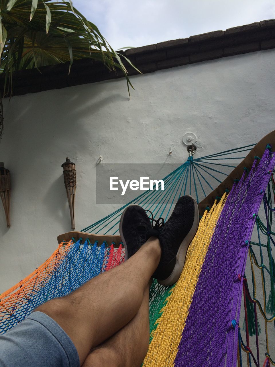 Low section of man lying on hammock