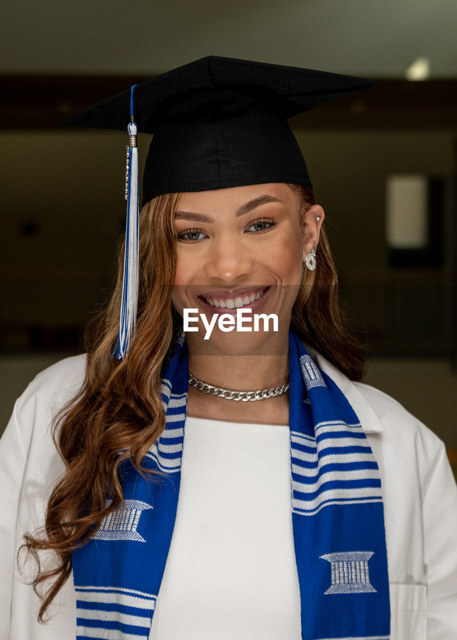 Portrait of smiling young woman wearing graduation gown