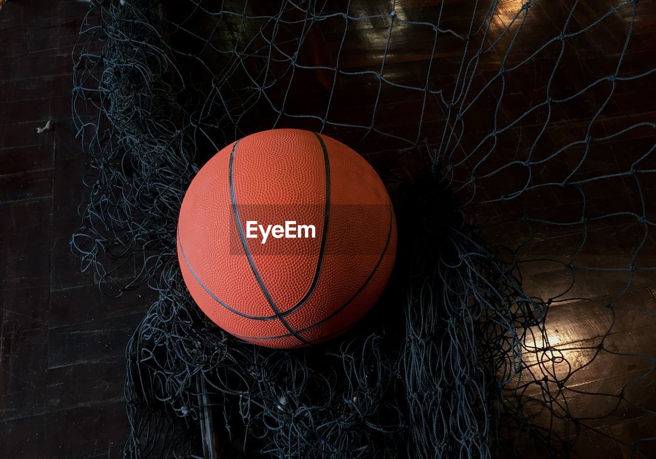 High angle view of basketball hitting net at night