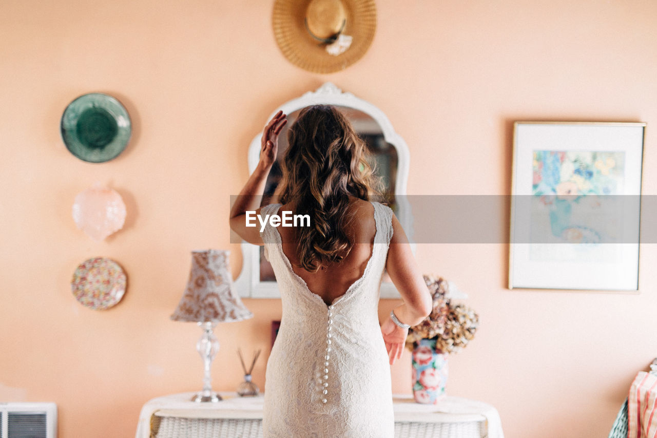 Rear view of bride standing at home