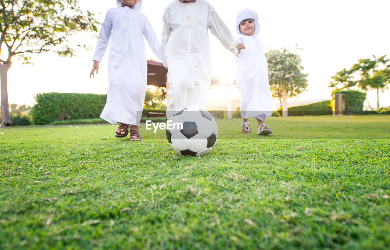 Boys playing with soccer ball on grass