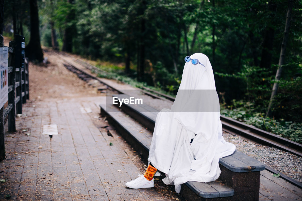 Ghost waits beside train tracks wearing sunglasses