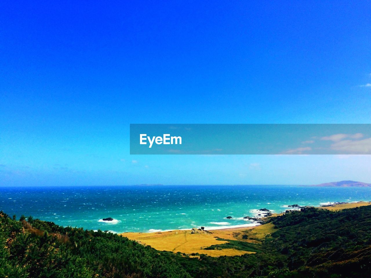 PANORAMIC VIEW OF BEACH AGAINST CLEAR BLUE SKY