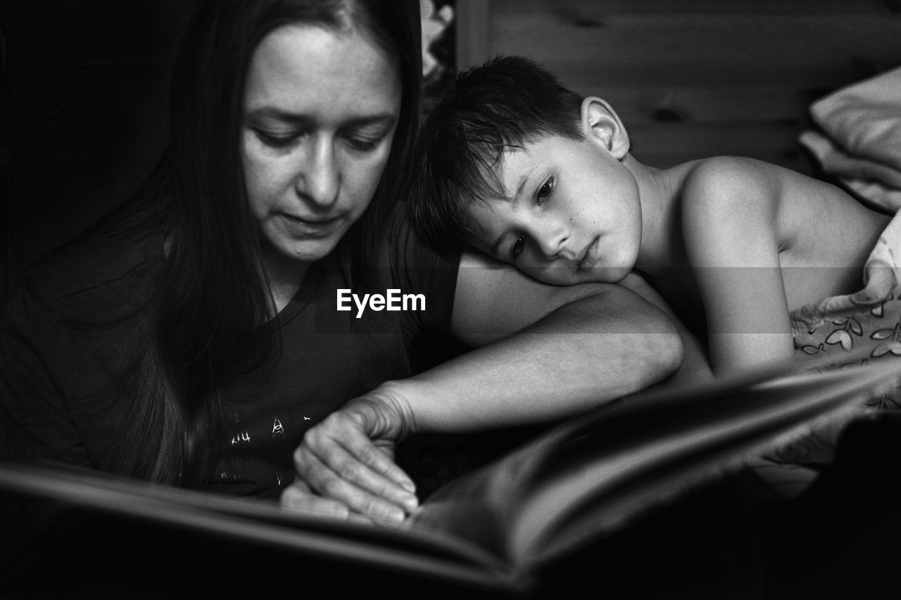 Mother reading book with son