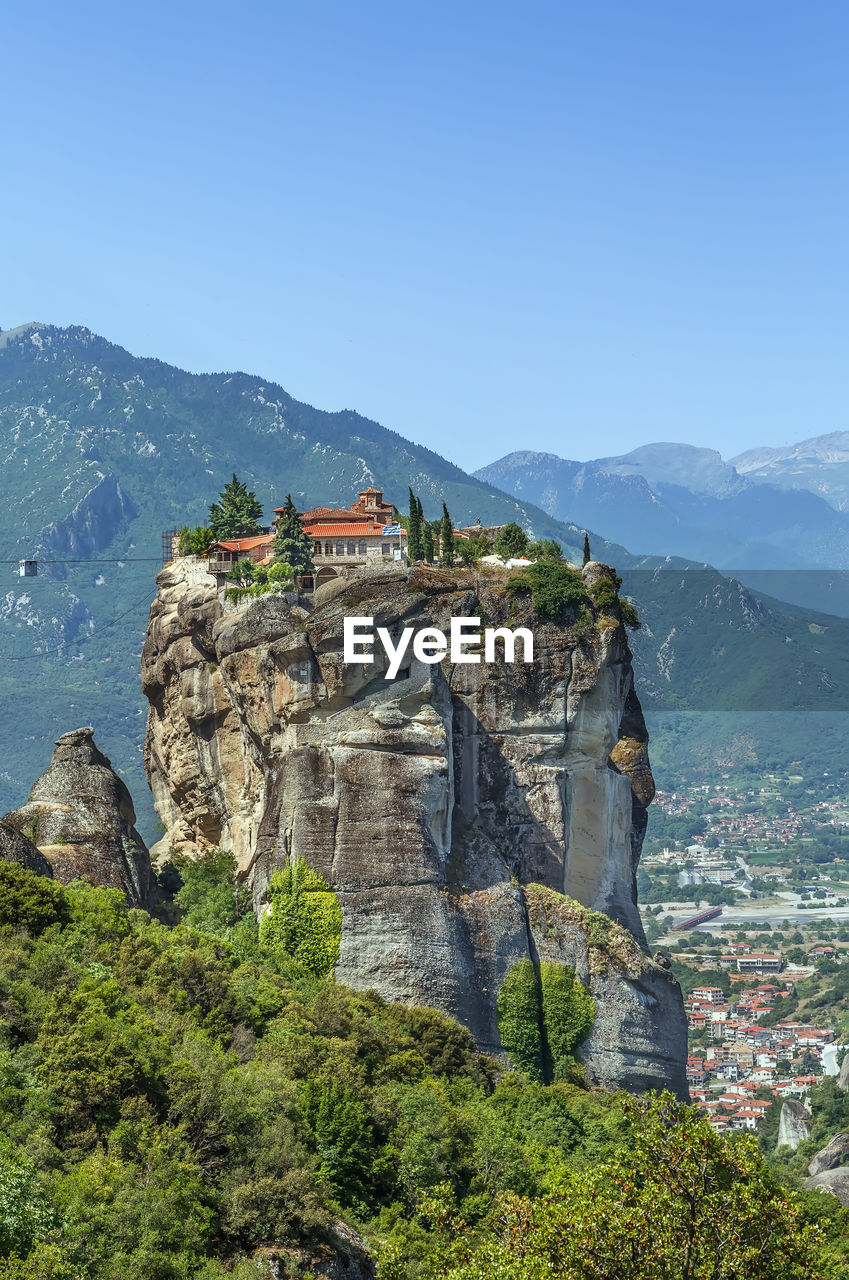 PLANTS AND BUILDINGS AGAINST MOUNTAIN RANGE