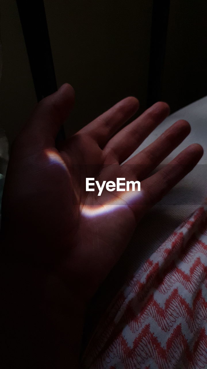 CLOSE-UP OF PERSON HAND ON BED AT HOME