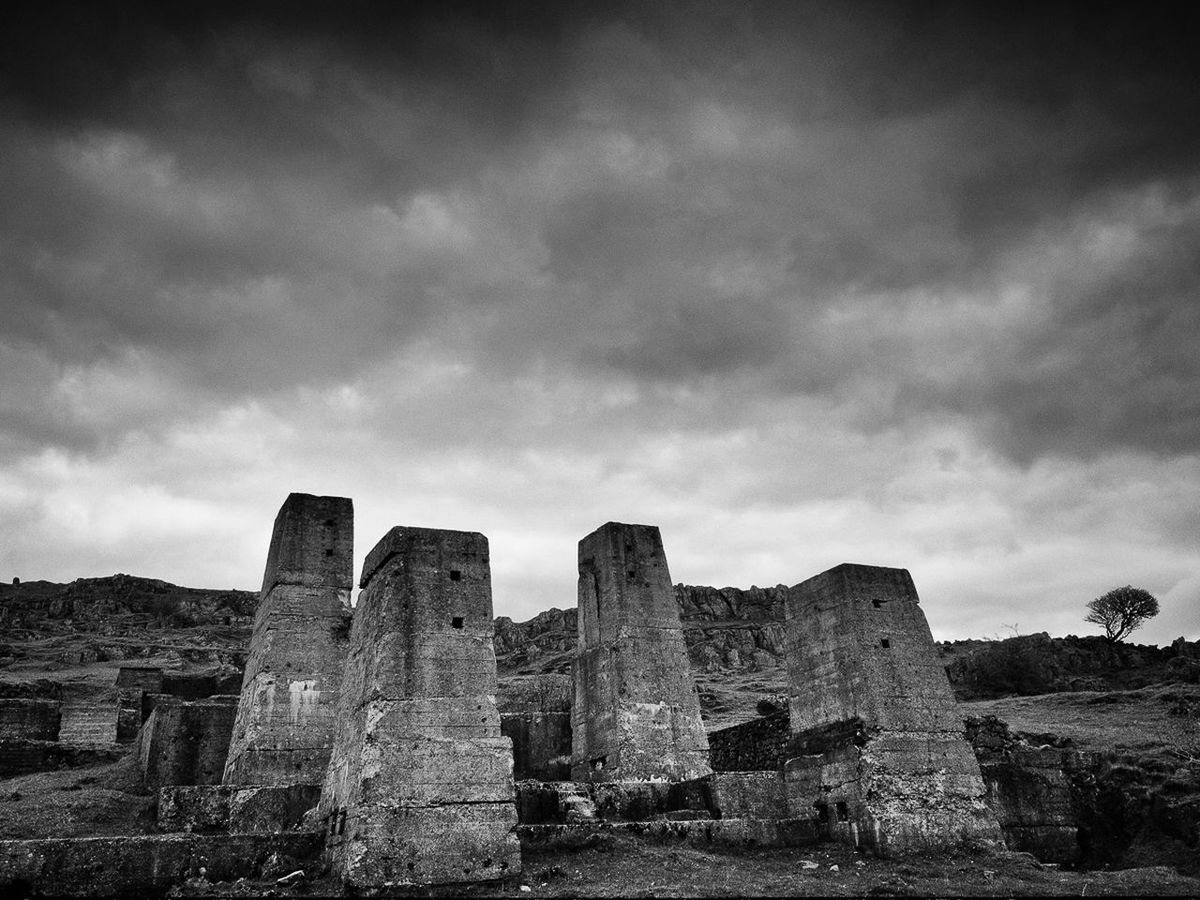 Abandoned historic buildings against cloudy sky