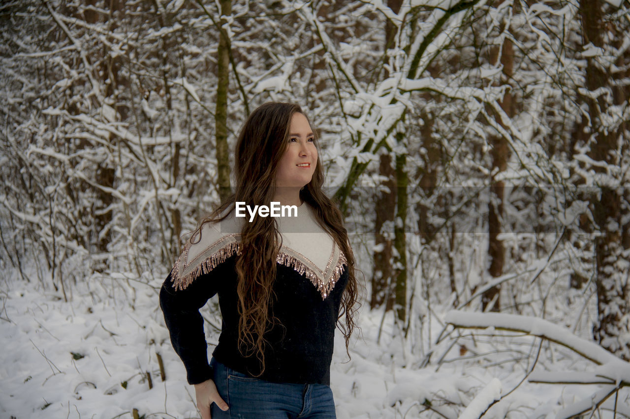 Young woman standing against among snow