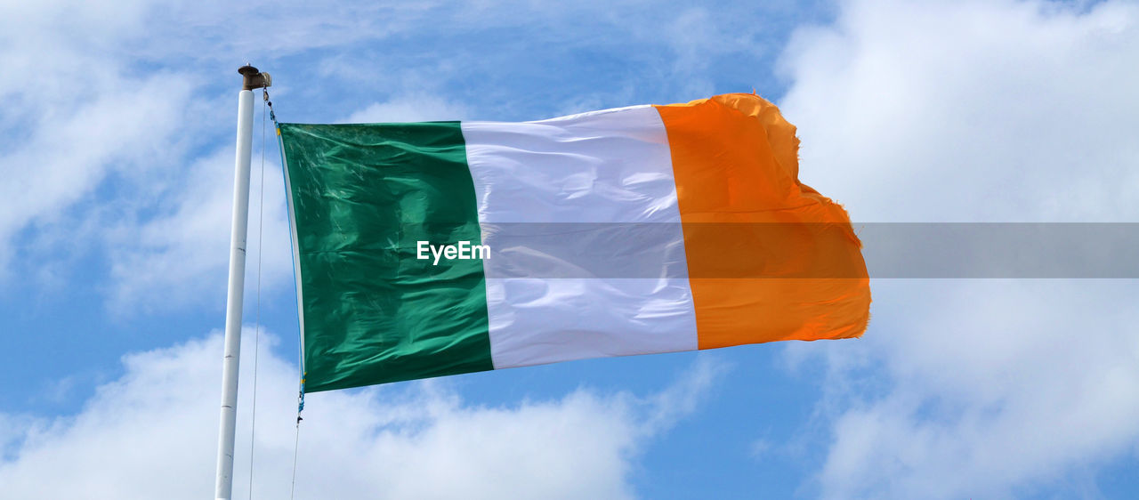 Low angle view of irish flag against sky