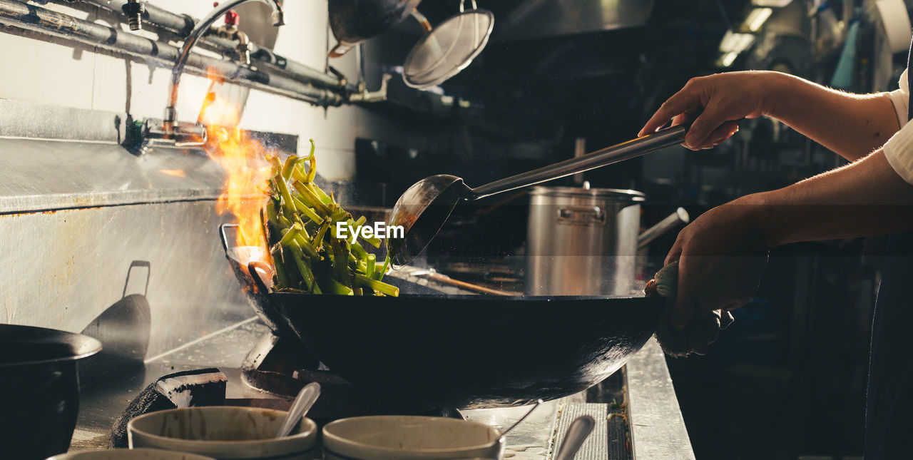 Chef stir fry busy cooking in kitchen. chef stir fry the food in a frying pan