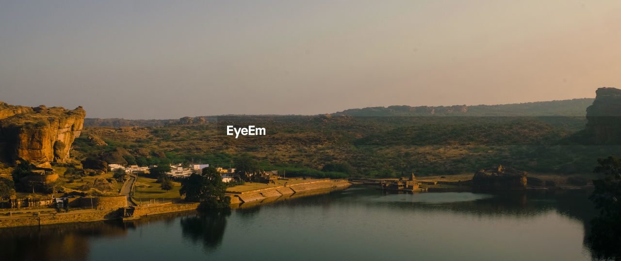 Scenic view of lake by buildings against clear sky