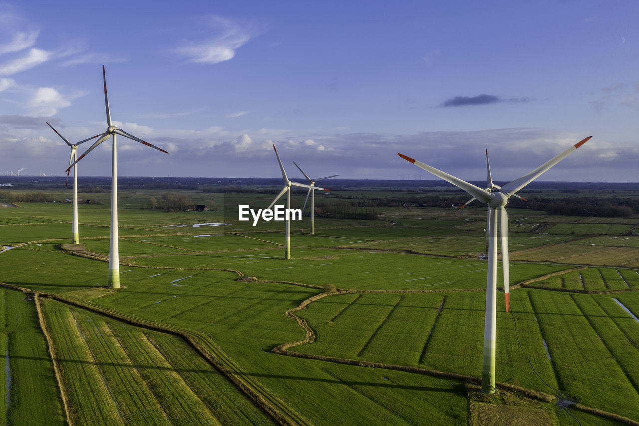 WIND TURBINES ON LAND AGAINST SKY