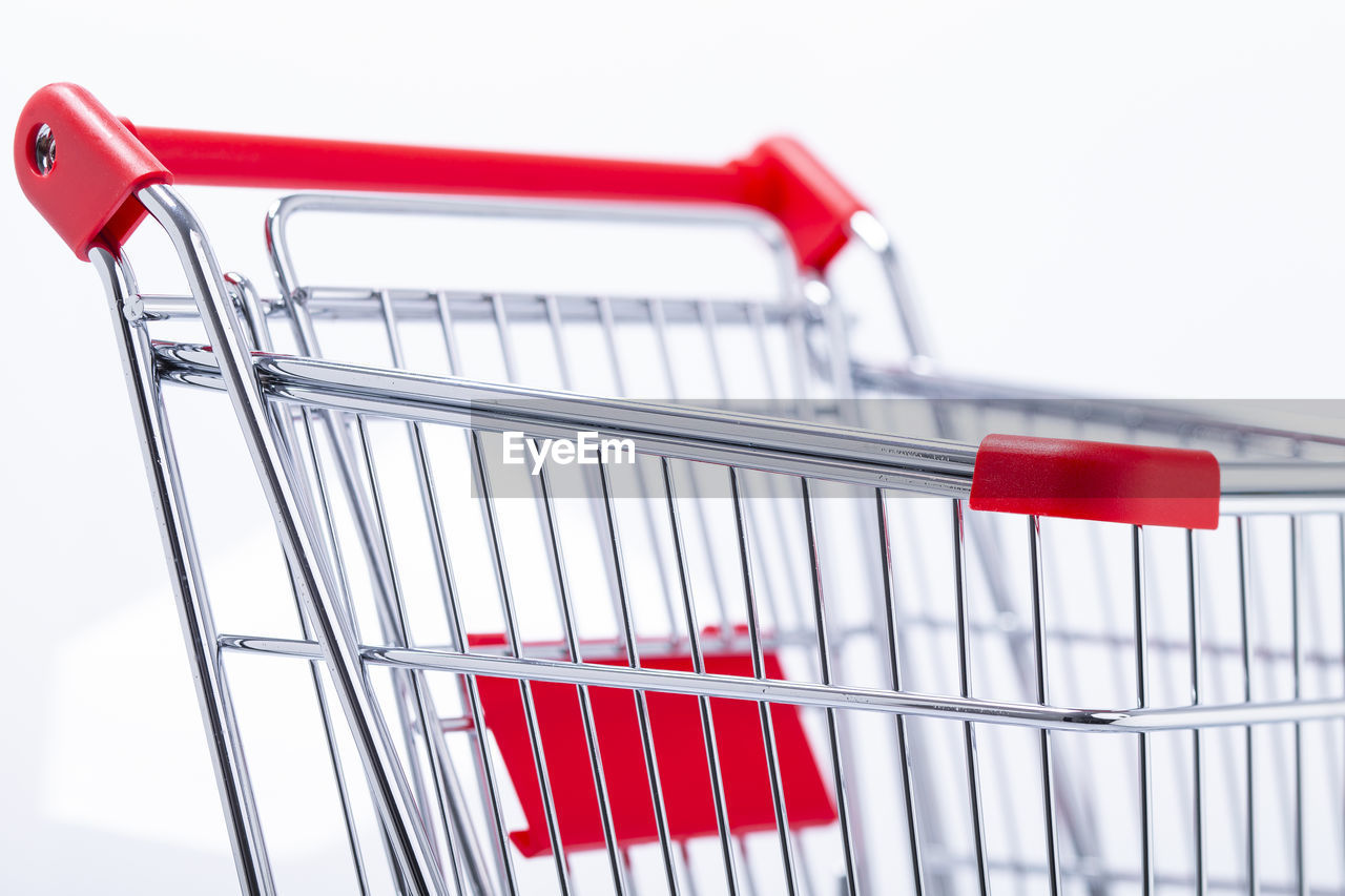 Close-up of shopping cart against white background