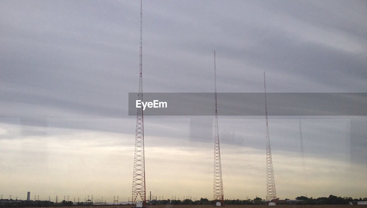 POWER LINES AGAINST CLOUDY SKY
