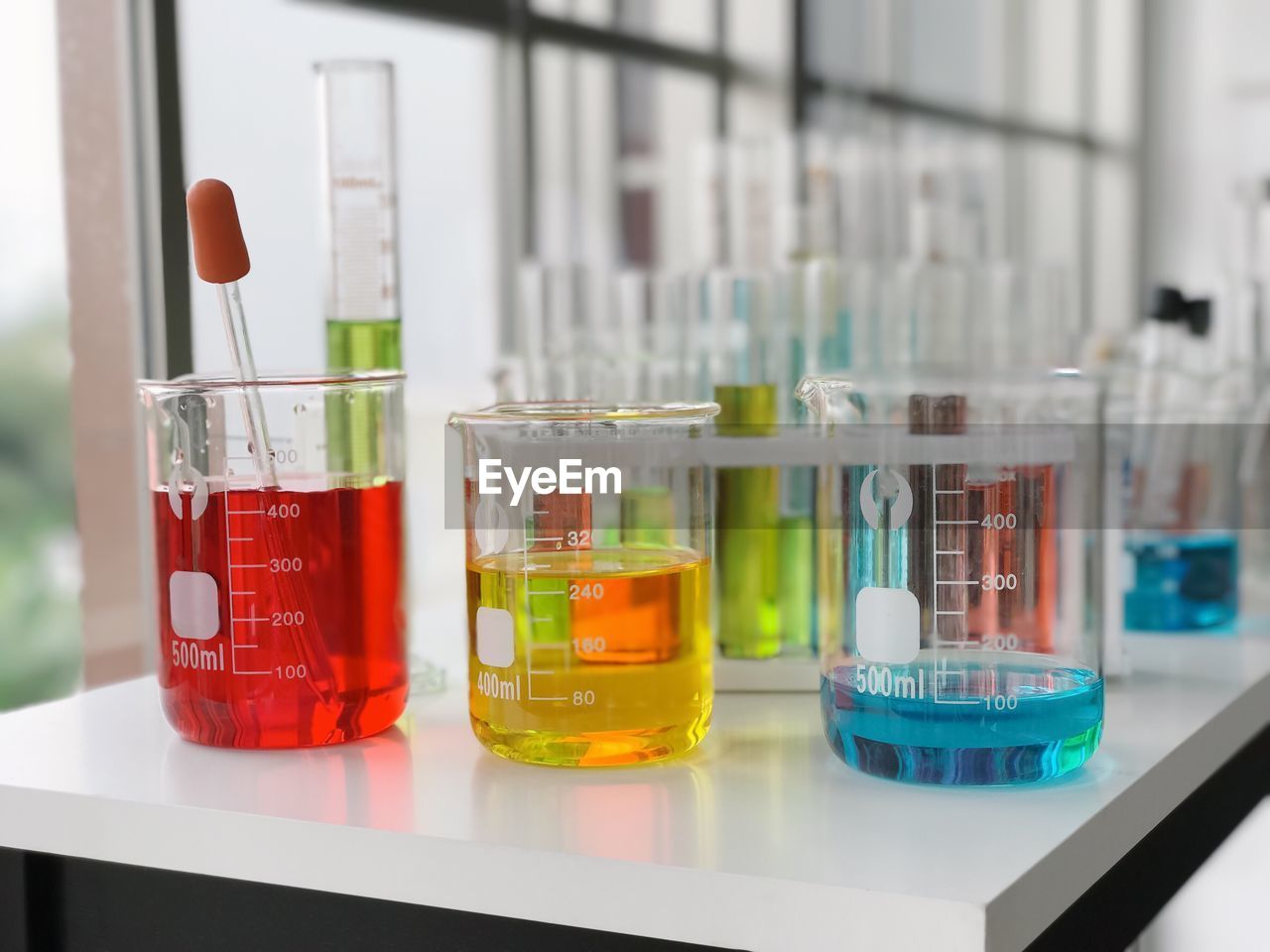 Multi colored chemicals in containers at laboratory