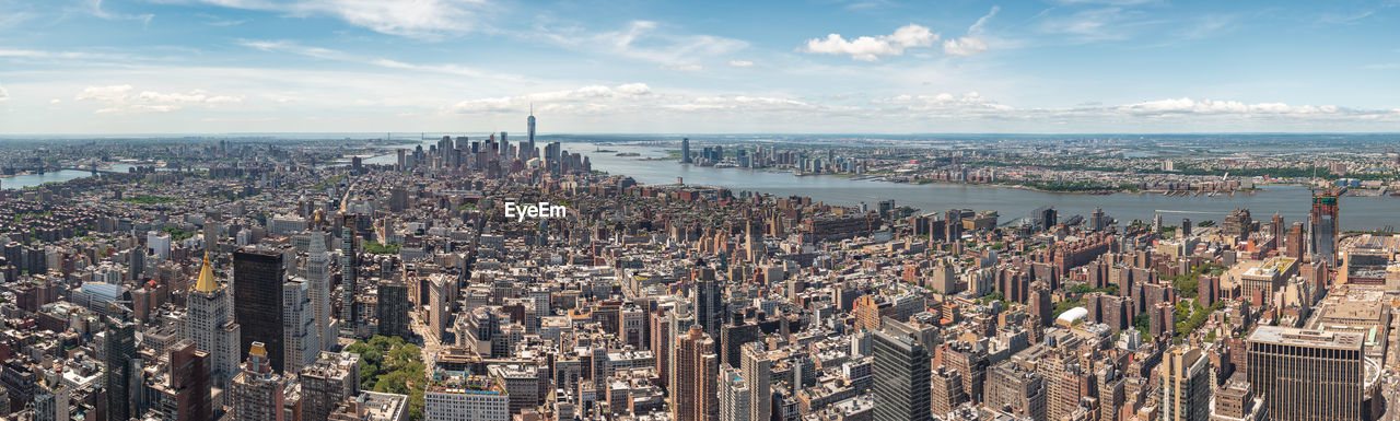 High angle view of modern buildings against cloudy sky