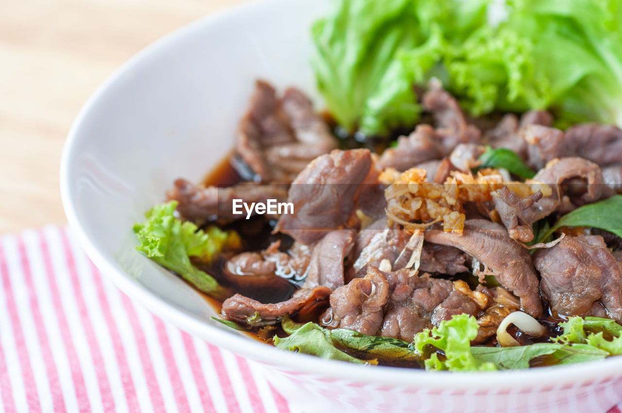 Chinese premium beef noodle with green lettuce topping with roasted 