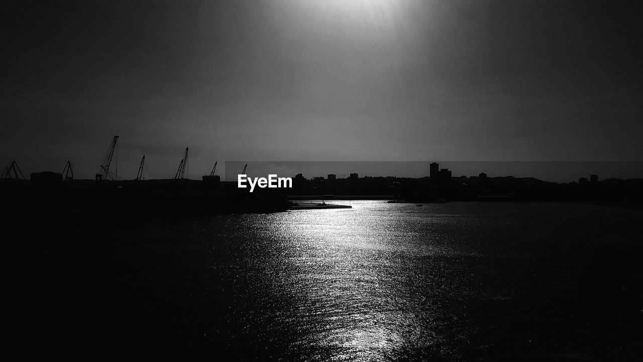 SCENIC VIEW OF SEA WITH SILHOUETTE TREES IN BACKGROUND