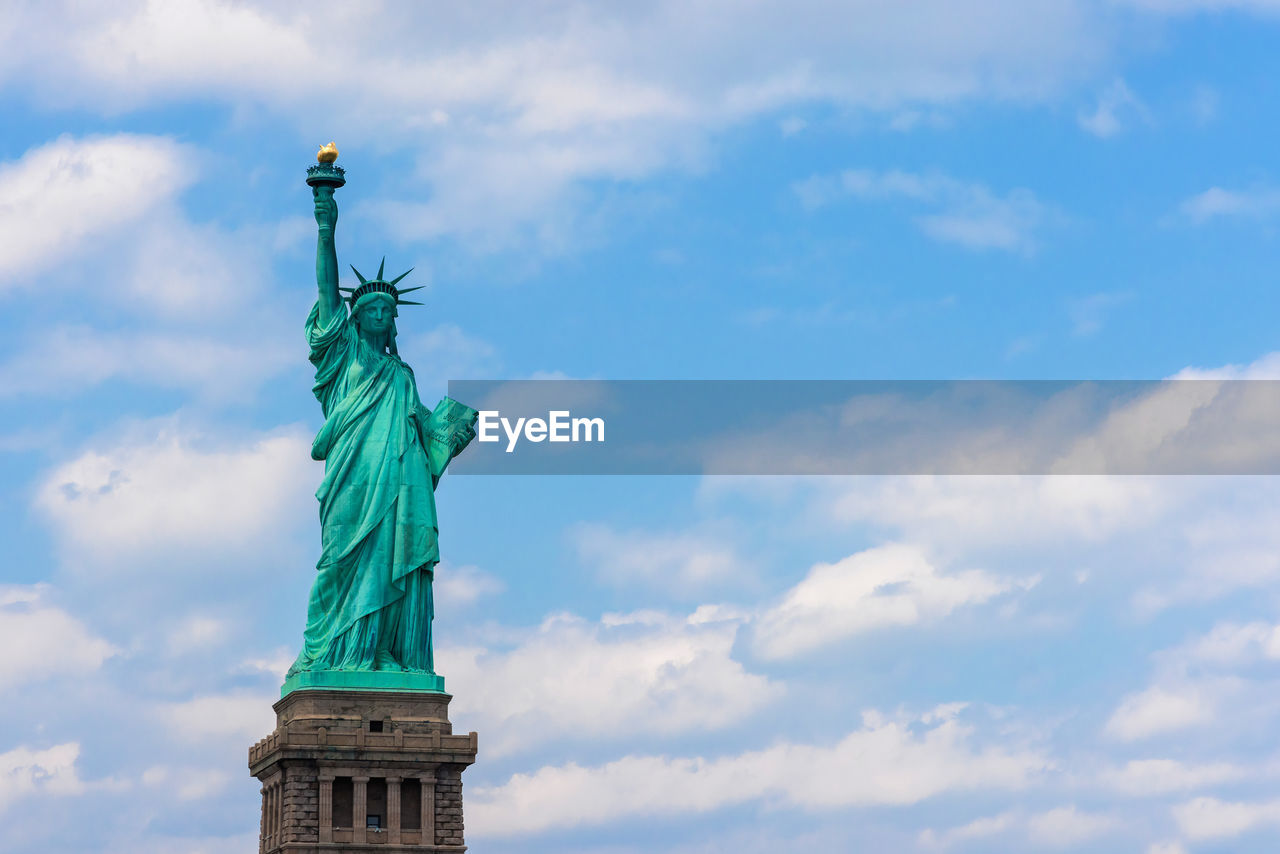 low angle view of statue of liberty against sky