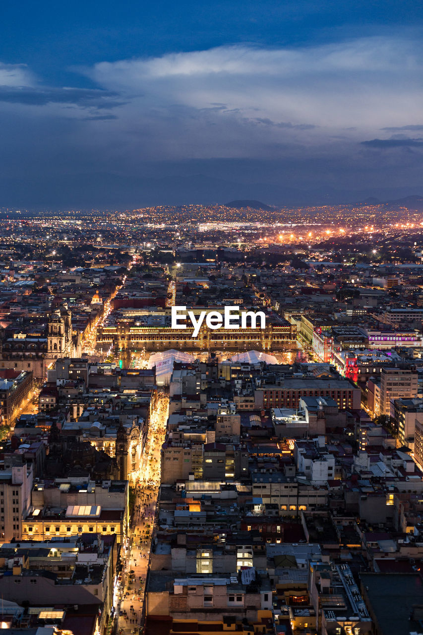 High angle view of illuminated city against sky at dusk