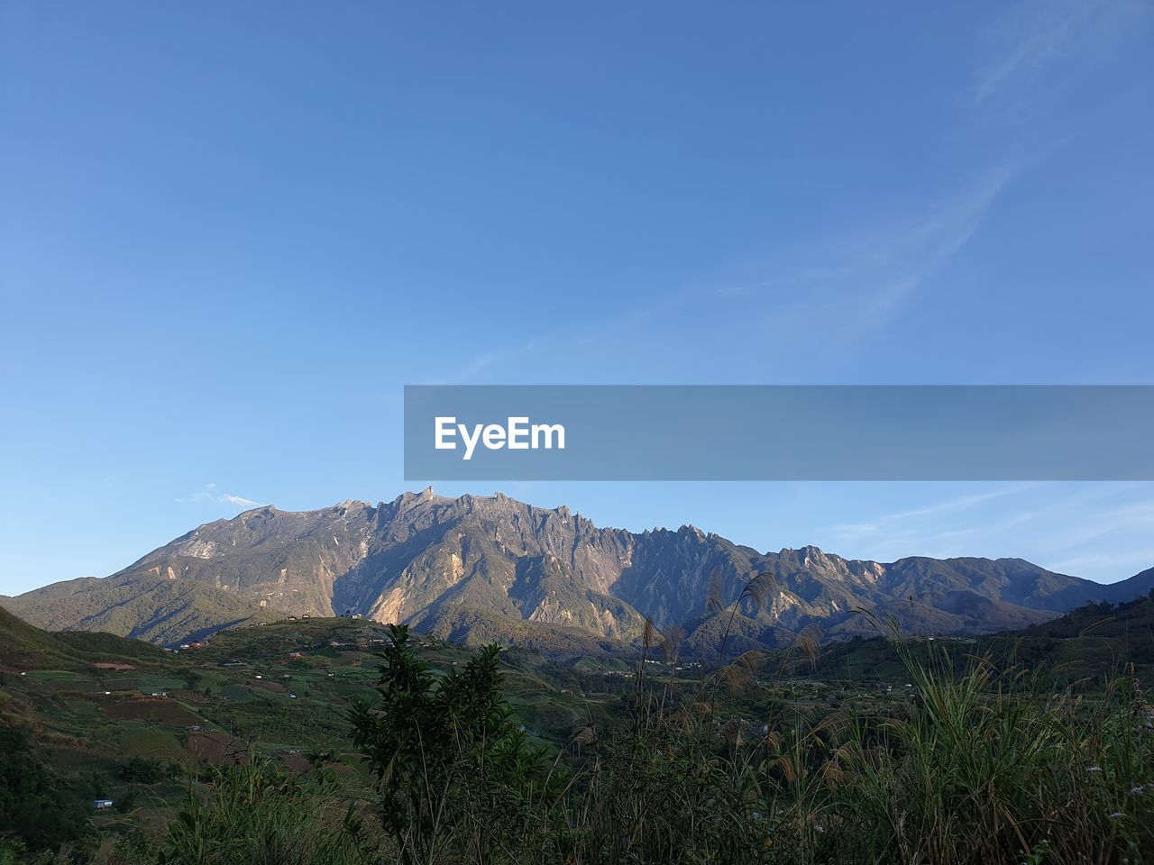 Scenic view of mountains against blue sky