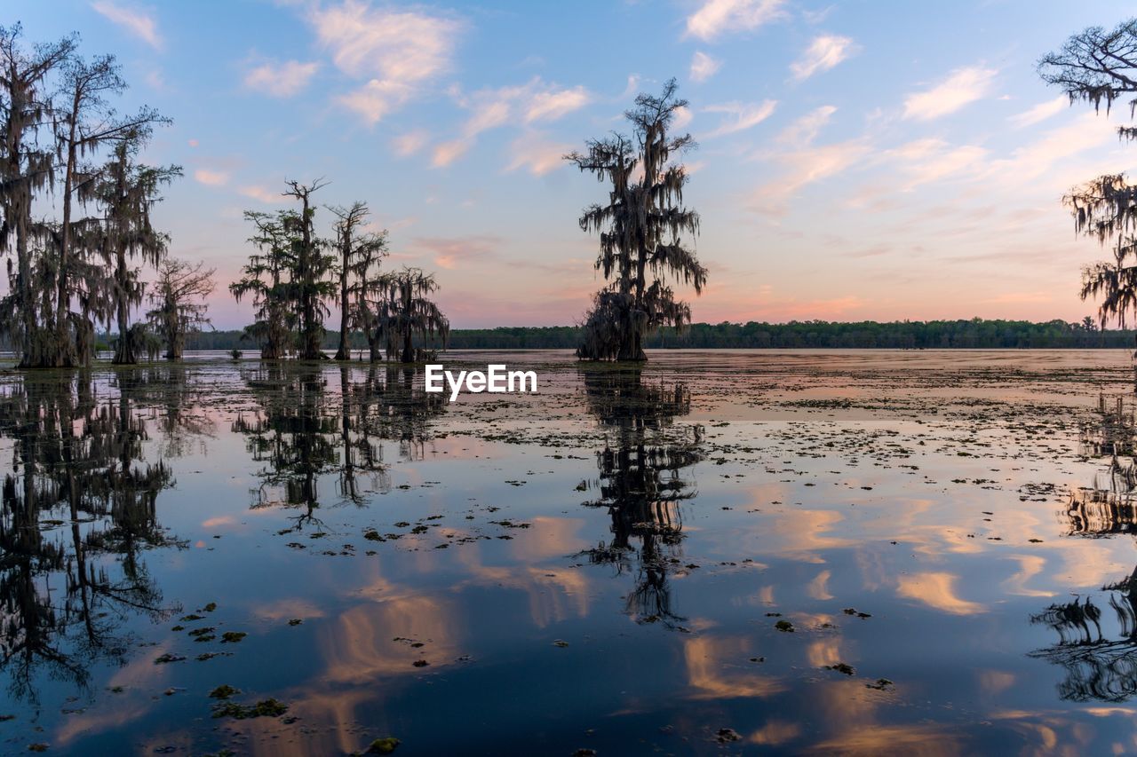 Scenic view of calm lake against cloudy sky