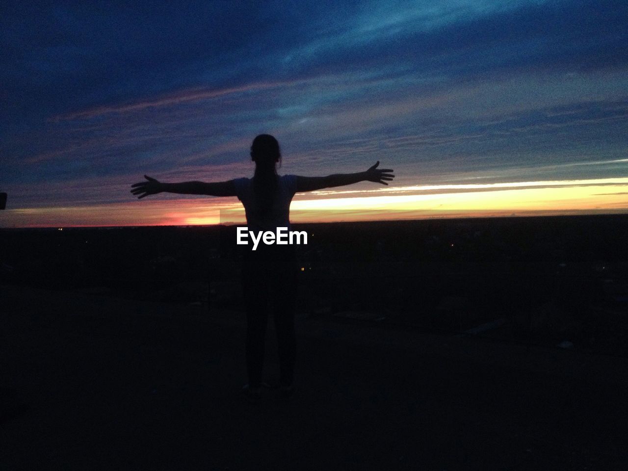 SILHOUETTE OF WOMAN STANDING ON LANDSCAPE AT SUNSET