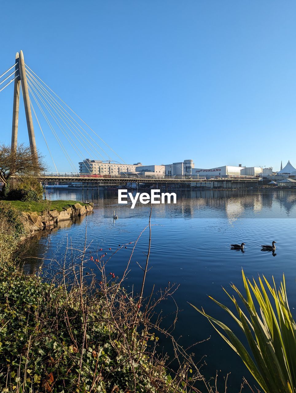 water, architecture, built structure, sky, reflection, bridge, nature, travel destinations, transportation, city, clear sky, river, building exterior, no people, travel, blue, tourism, morning, shore, reservoir, suspension bridge, plant, horizon, day, outdoors, building, landscape, beauty in nature, cityscape, copy space, scenics - nature, nautical vessel, tranquility, sunny, environment, tranquil scene, dusk