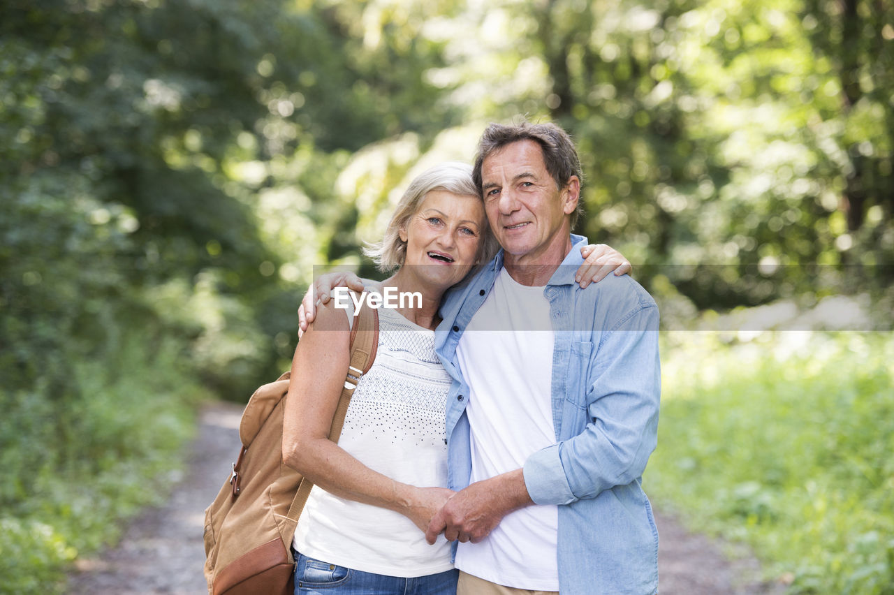 Portrait of happy senior couple relaxing together in the woods