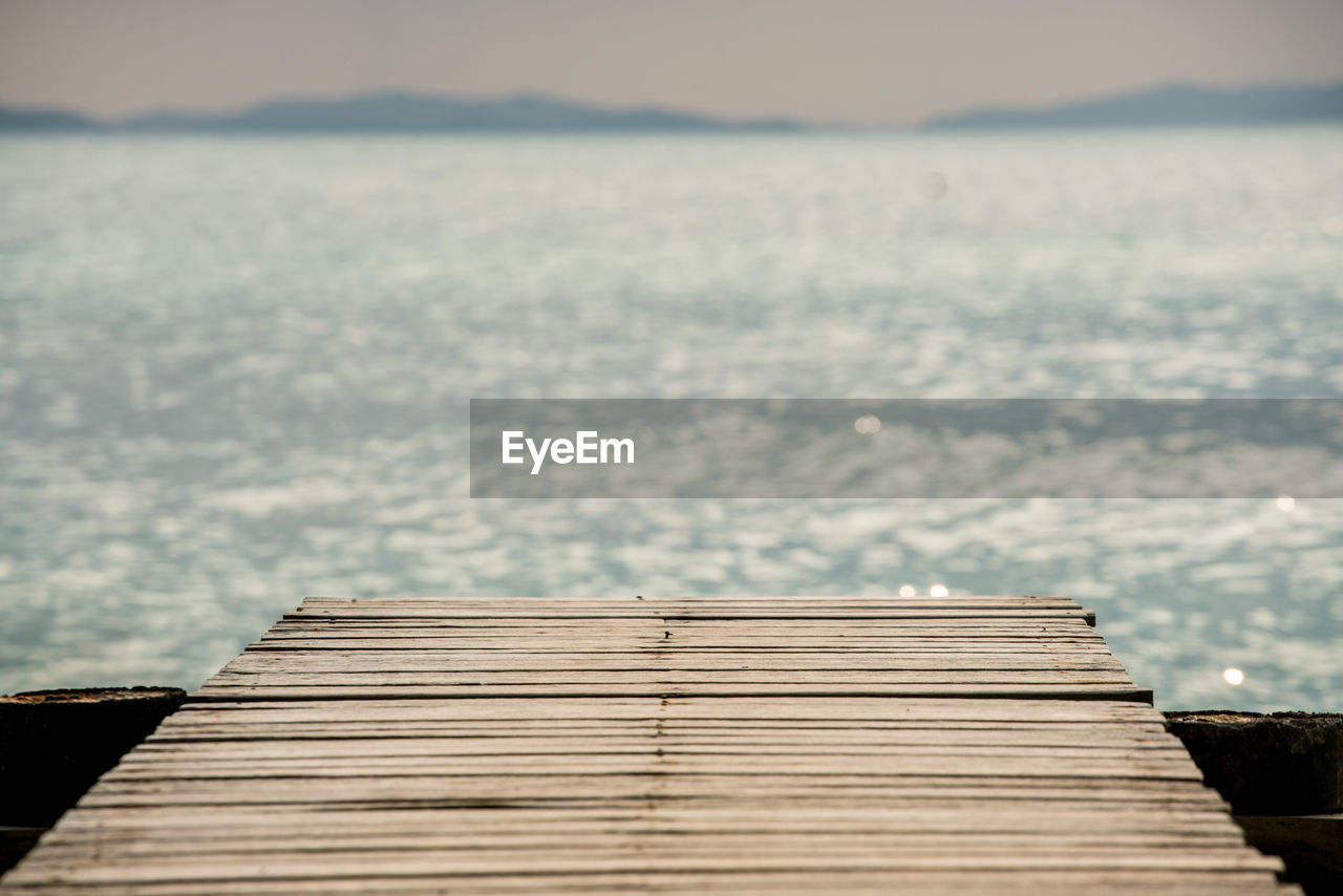 Empty pier over sea against sky