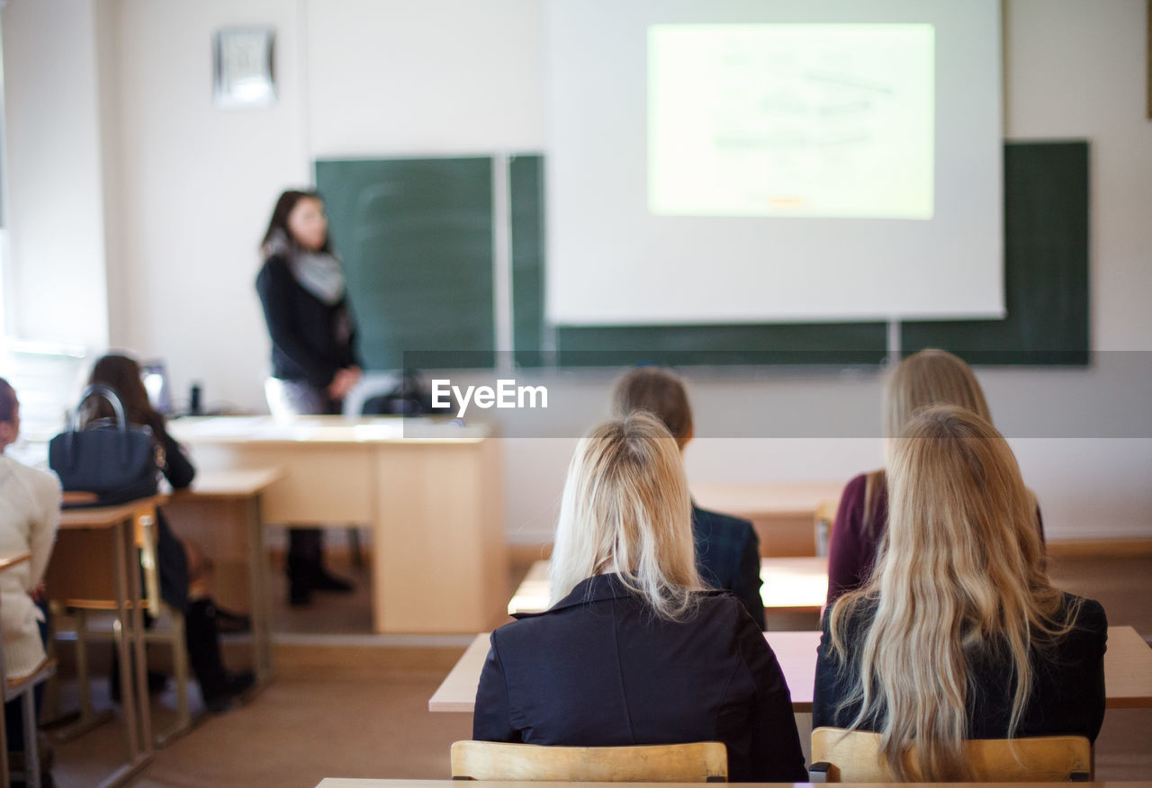 Rear view of students sitting in classroom