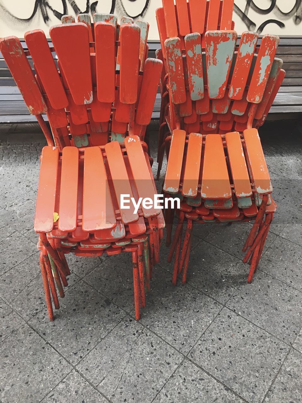 High angle view of orange stacked chairs on footpath