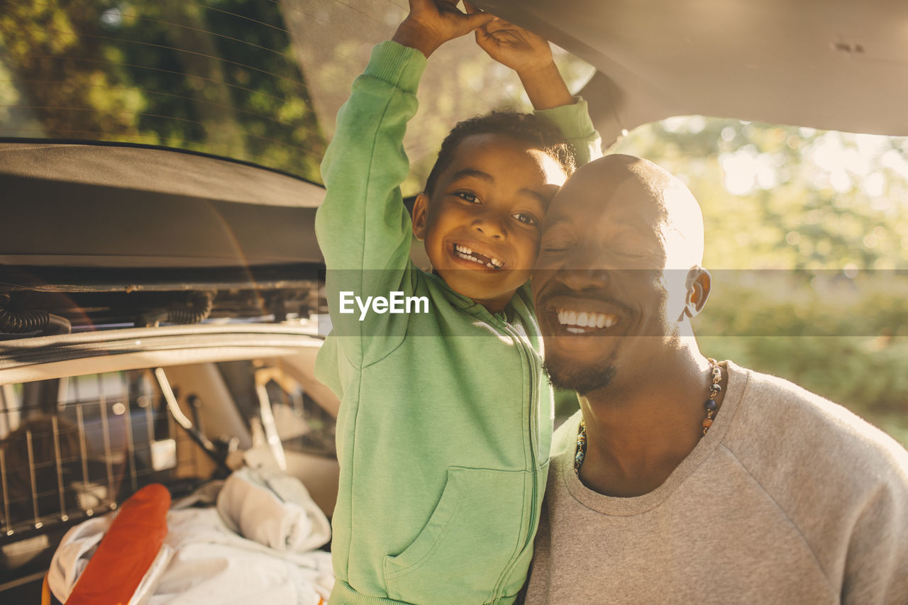 Portrait of smiling boy with father at picnic spot in park