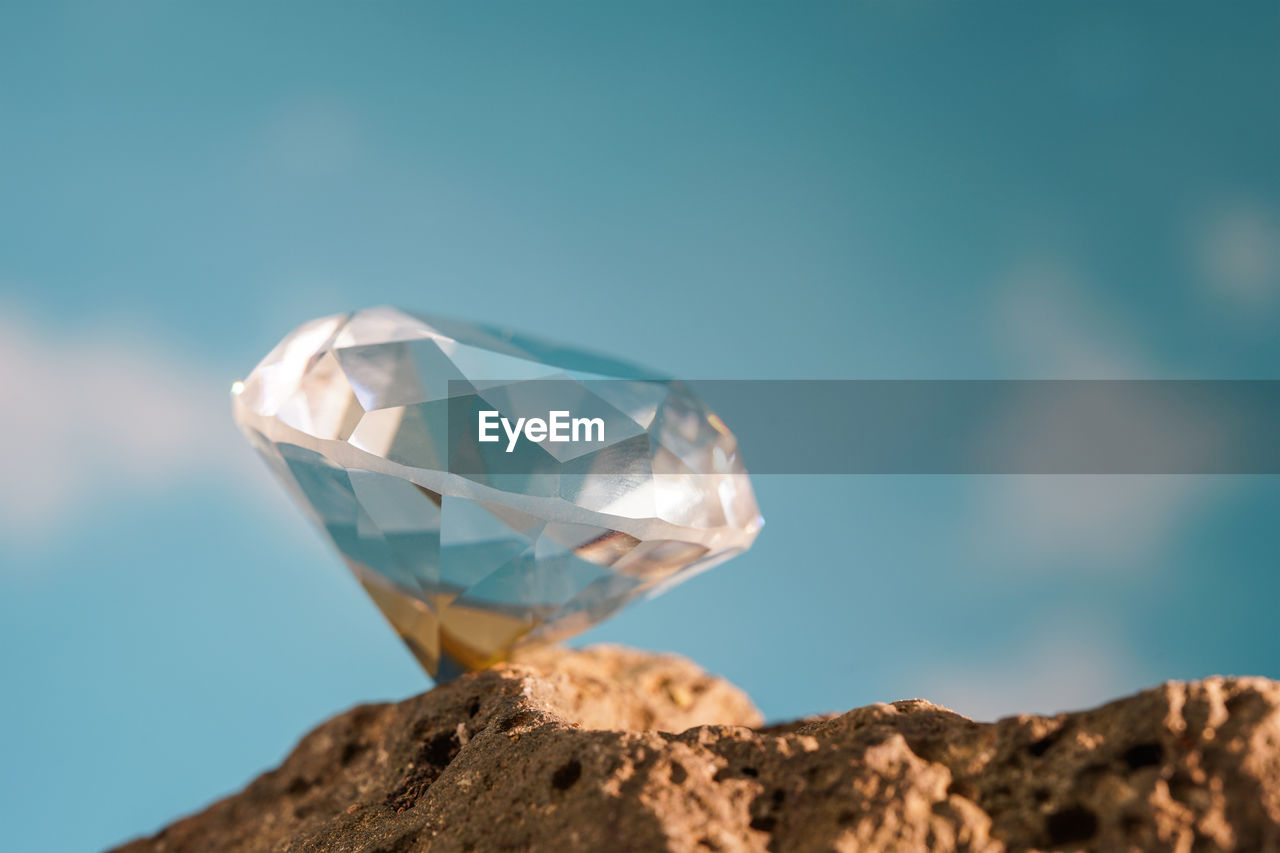 blue, rock, nature, jewelry, gemstone, no people, sky, outdoors, crystal, single object, geology, diamond, close-up, transparent, macro photography, copy space, mineral, wealth, shiny