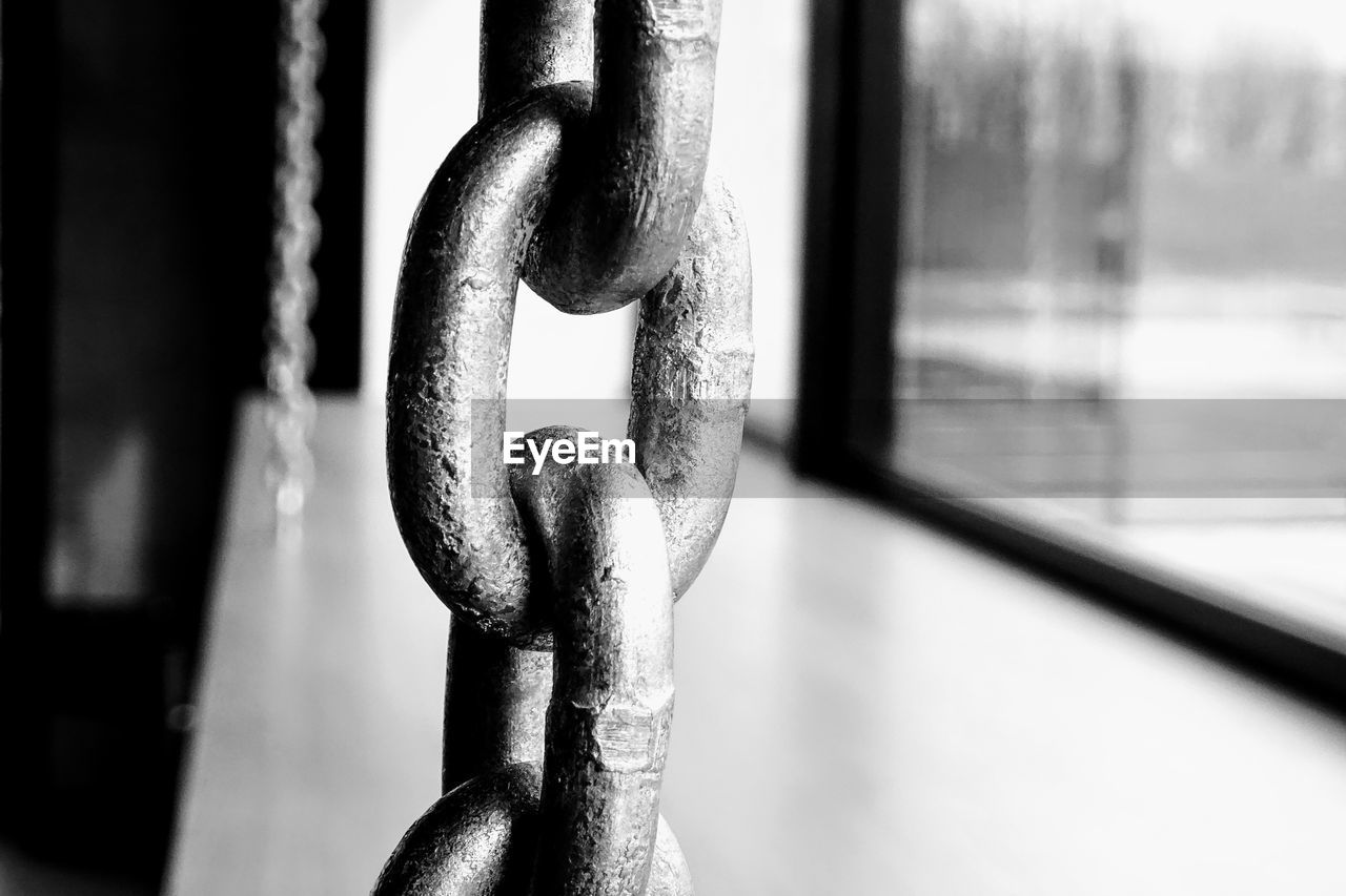 CLOSE-UP OF CHAIN AGAINST METAL