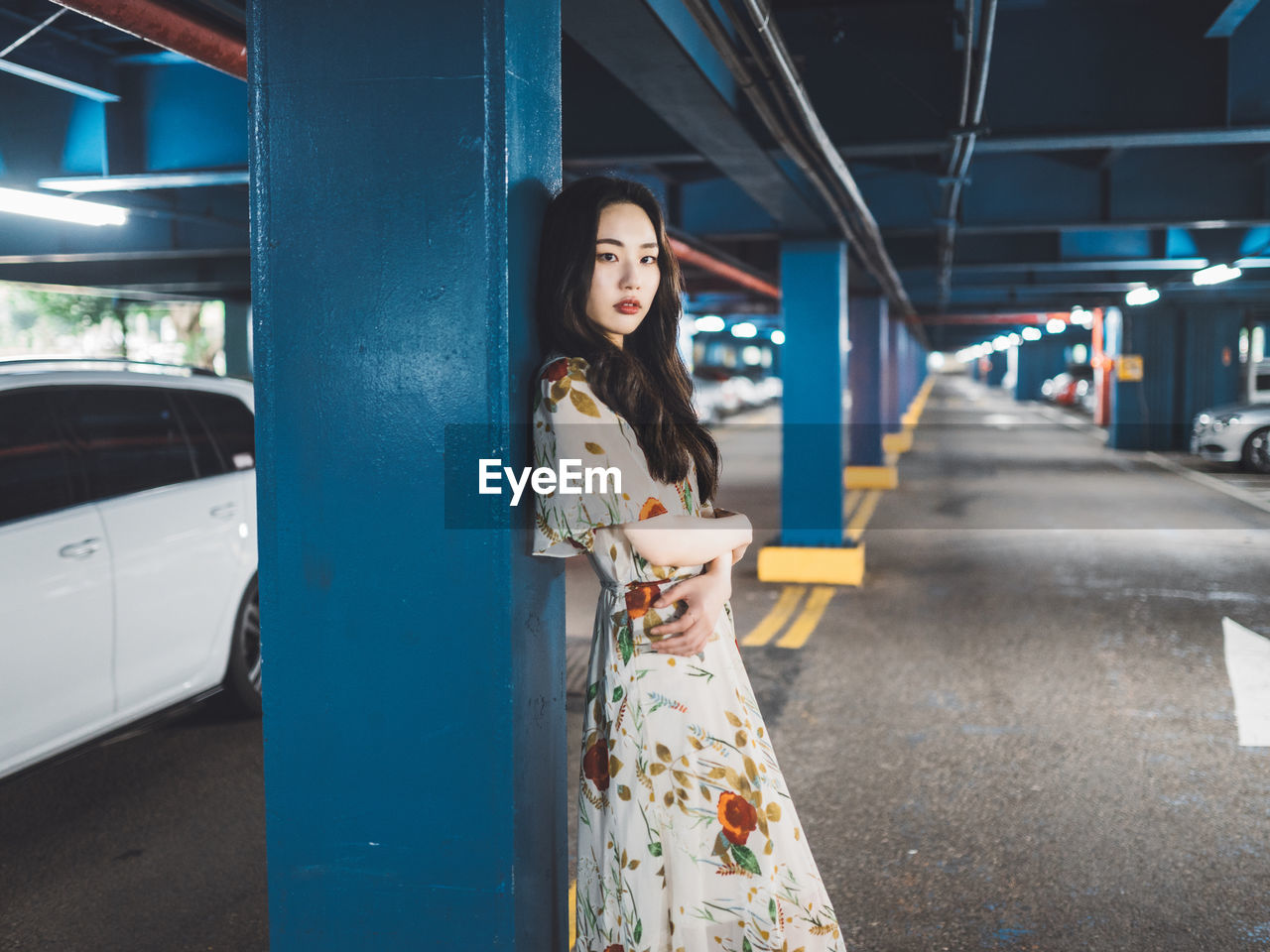 PORTRAIT OF YOUNG WOMAN STANDING AT BUS