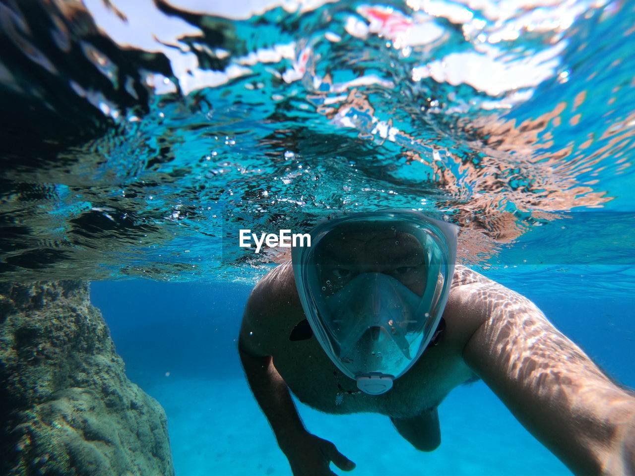 Mature man swimming under sea